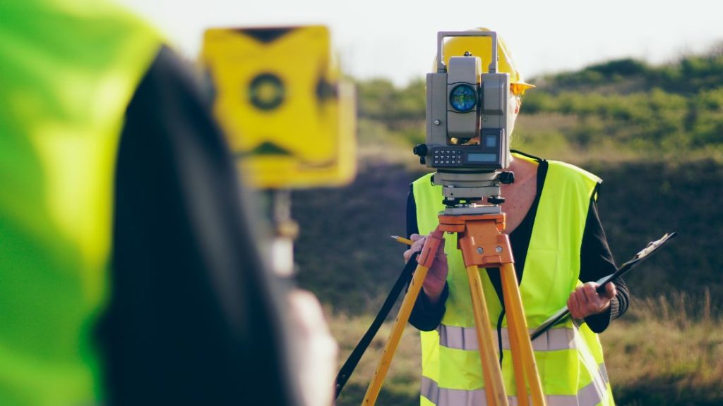 surveyor with surveying kit measuring the landscape